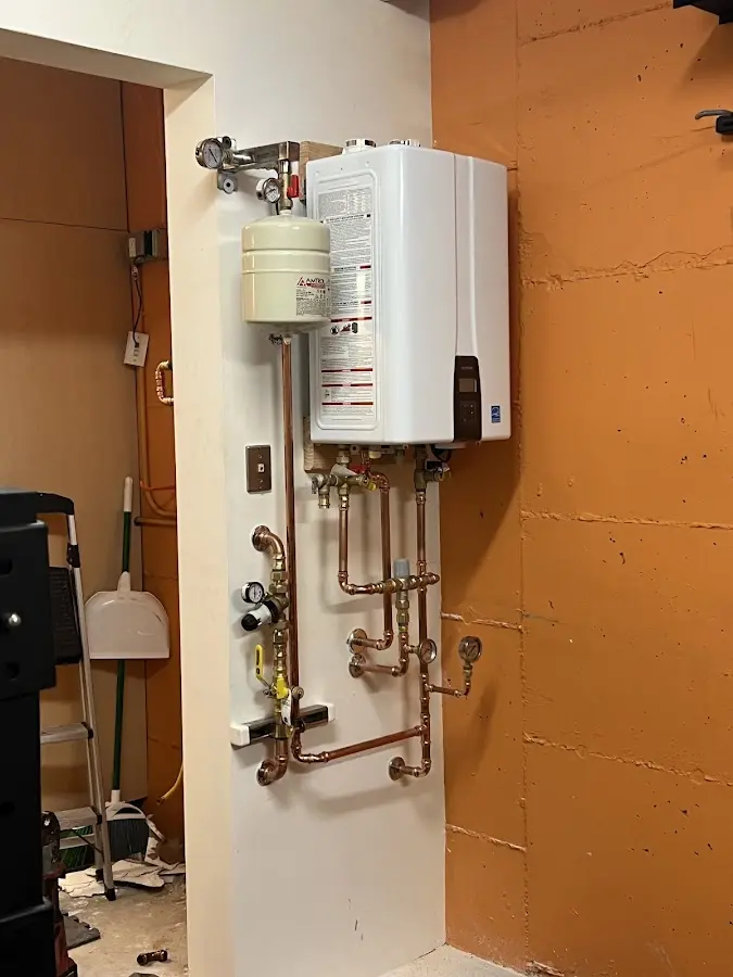 Plumbing technician inspecting water heater connections in Dallas